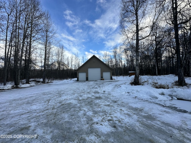 yard covered in snow featuring a garage and an outdoor structure