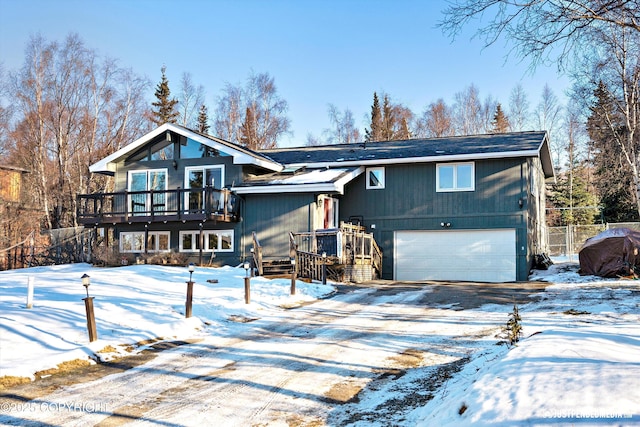 rustic home with an attached garage, driveway, and a wooden deck