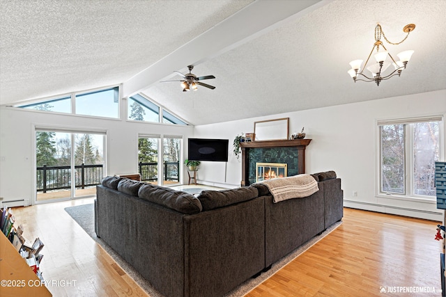 living room featuring a baseboard heating unit, light wood finished floors, lofted ceiling with beams, and a healthy amount of sunlight