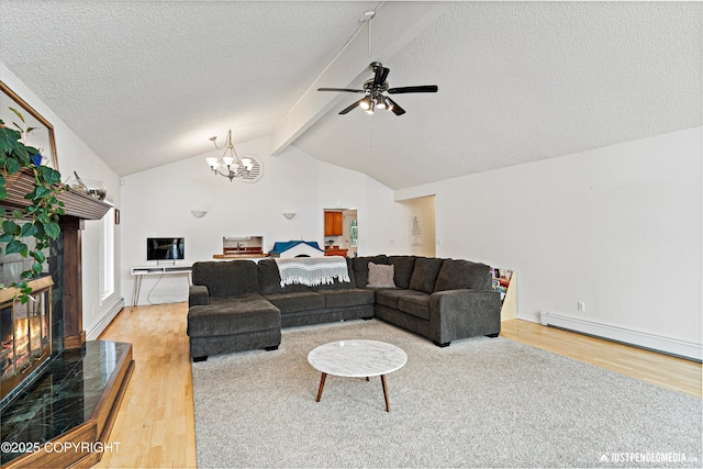 living room with a tiled fireplace, a baseboard radiator, wood finished floors, vaulted ceiling with beams, and a textured ceiling