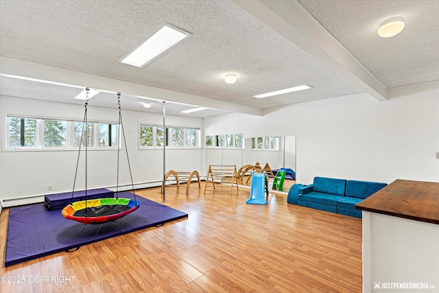 rec room with a textured ceiling and wood finished floors