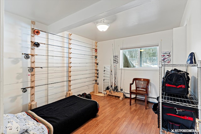 bedroom featuring baseboard heating and wood finished floors