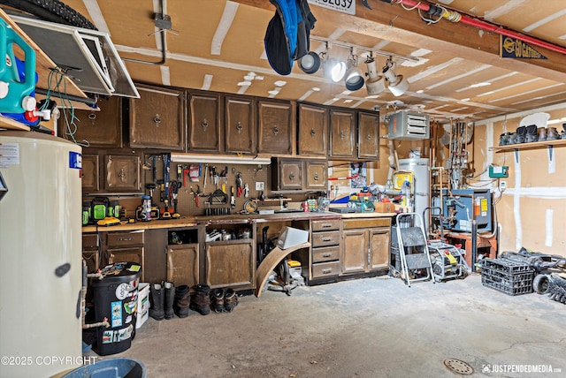 garage with secured water heater, water heater, and a workshop area