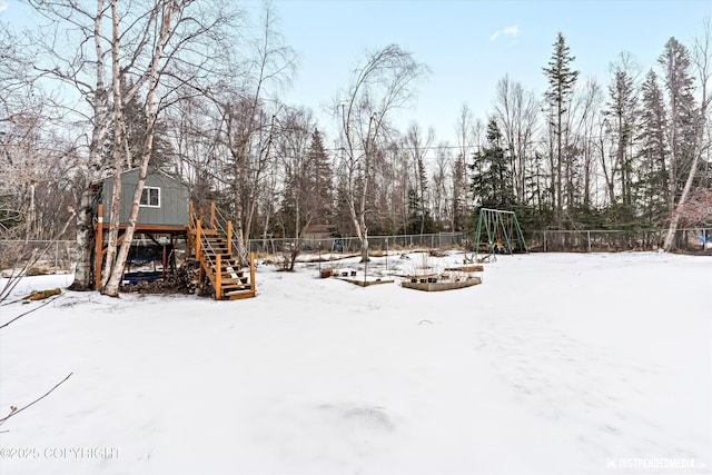 yard covered in snow with a playground and fence