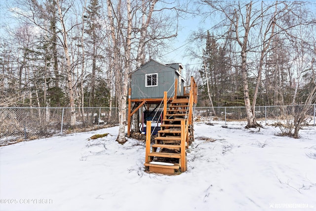 snow covered house featuring fence