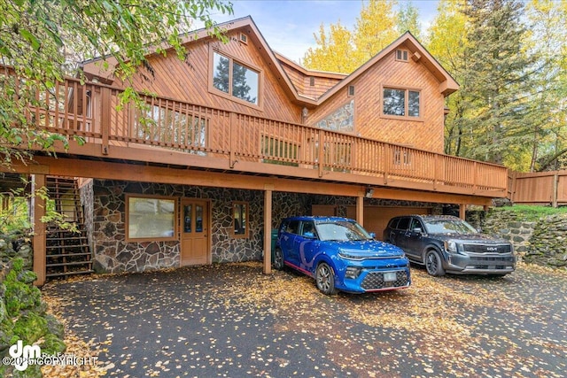 view of front of home with stone siding and a deck