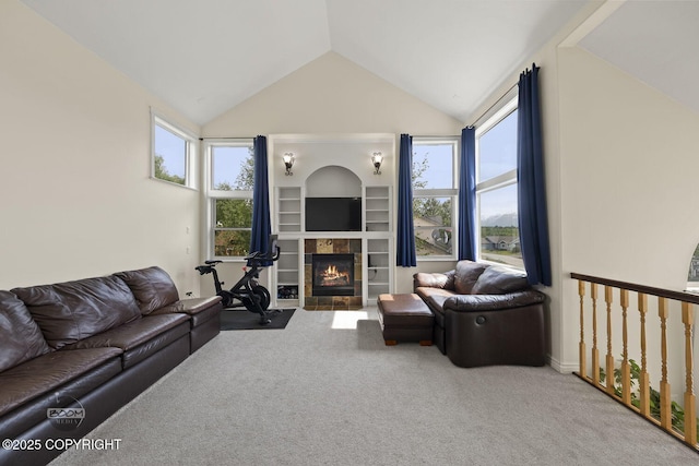 1968 S Paddock Dr, Wasilla, AK 99654 - carpeted living area featuring vaulted ceiling, a tiled fireplace, plenty of natural light, and built in shelves