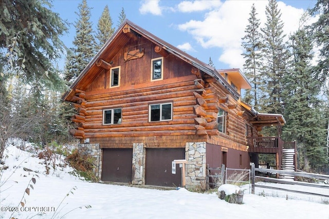 view of snow covered exterior with a garage