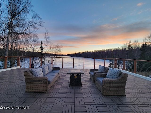 patio terrace at dusk featuring a water view and outdoor lounge area