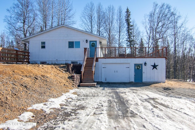 view of front facade featuring driveway, a garage, stairway, crawl space, and a deck