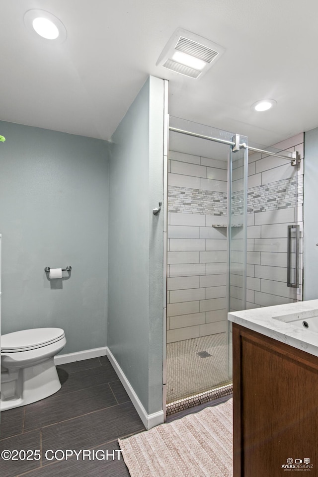 full bathroom featuring toilet, a stall shower, baseboards, and visible vents