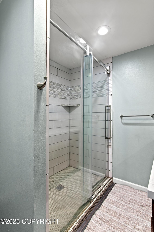 full bath with a shower stall and baseboards