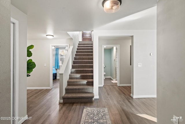 stairway with baseboards and wood finished floors