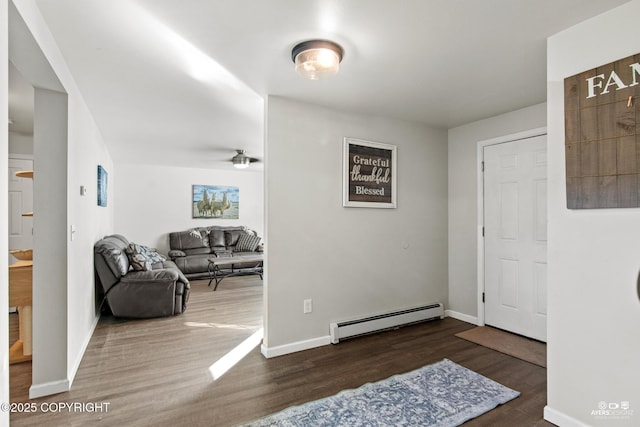 foyer with a baseboard heating unit, wood finished floors, and baseboards