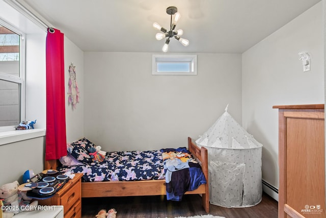 bedroom featuring a baseboard radiator, an inviting chandelier, and wood finished floors