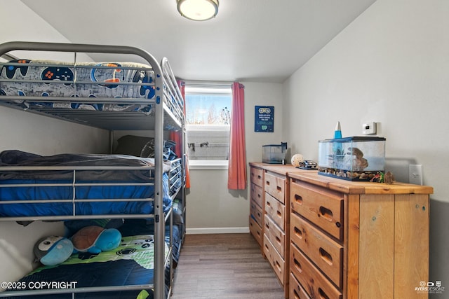 bedroom with baseboards and wood finished floors