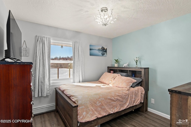 bedroom featuring baseboards, a textured ceiling, a baseboard heating unit, and wood finished floors