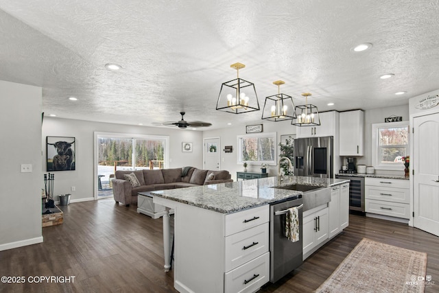 kitchen with beverage cooler, dark wood-type flooring, appliances with stainless steel finishes, and open floor plan