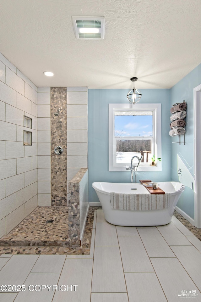 full bath featuring a soaking tub, a textured ceiling, visible vents, and tiled shower