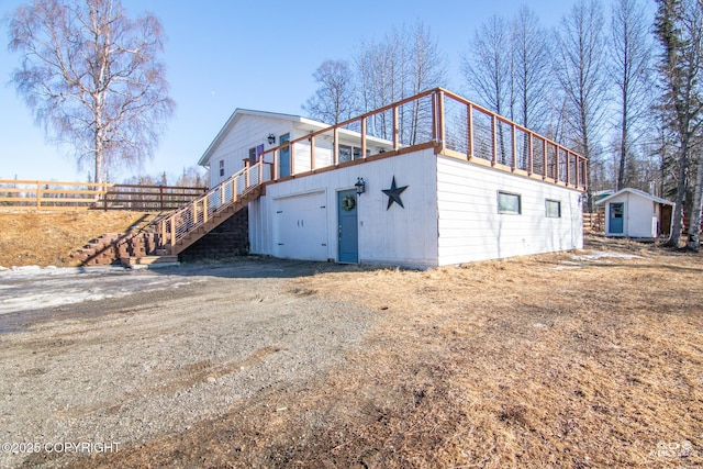 exterior space with an outbuilding, fence, and stairway