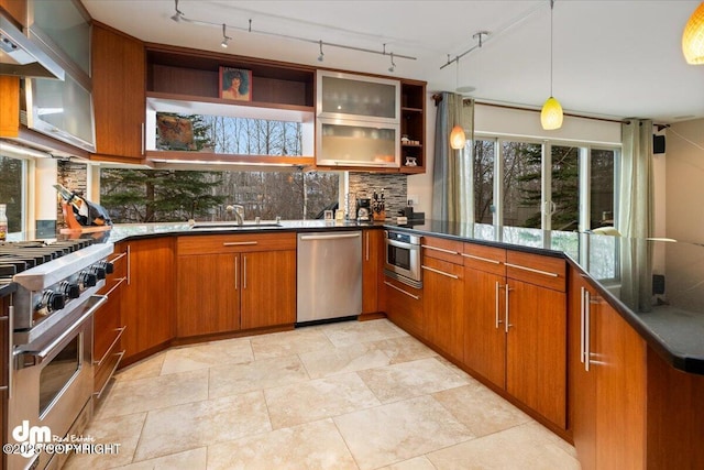 kitchen with appliances with stainless steel finishes, open shelves, brown cabinetry, dark countertops, and decorative light fixtures