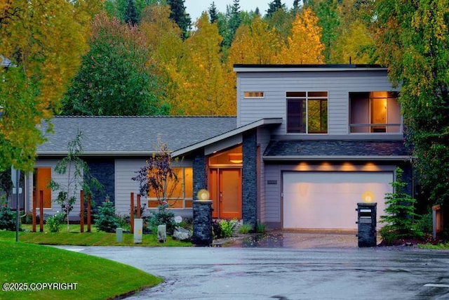 view of front of property with driveway, an attached garage, and a front lawn