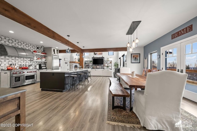 dining area featuring recessed lighting, beamed ceiling, and light wood-style flooring