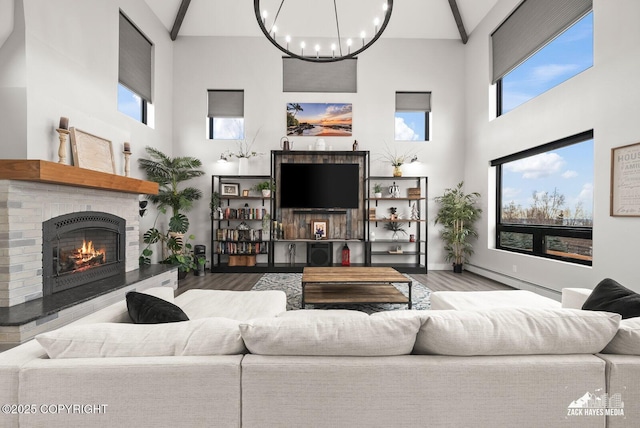 living room featuring a baseboard radiator, wood finished floors, a healthy amount of sunlight, and a chandelier