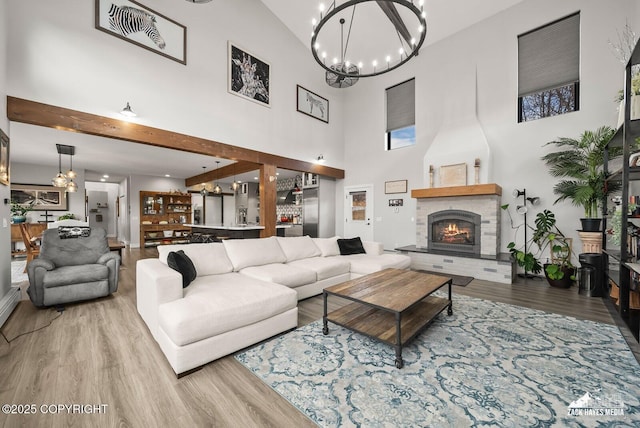 living room featuring a fireplace, wood finished floors, and a chandelier