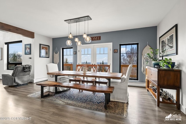 dining room featuring beamed ceiling, baseboard heating, a baseboard heating unit, and wood finished floors