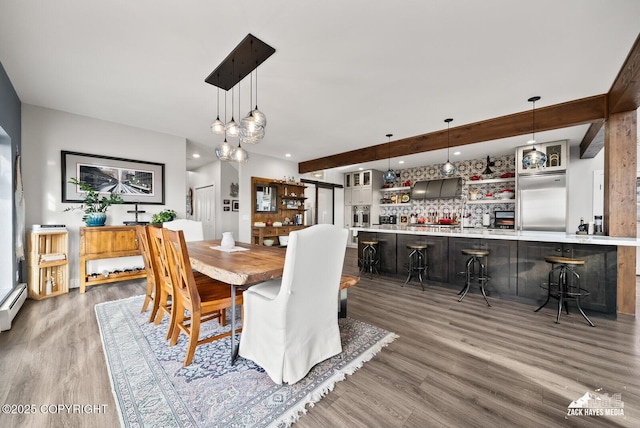 dining area featuring a dry bar, recessed lighting, wood finished floors, and a baseboard radiator