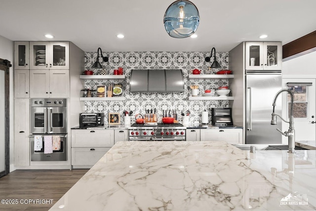 kitchen with open shelves, light stone counters, and premium appliances