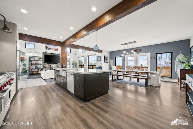 kitchen with beam ceiling, a sink, dark wood-style floors, open floor plan, and light countertops