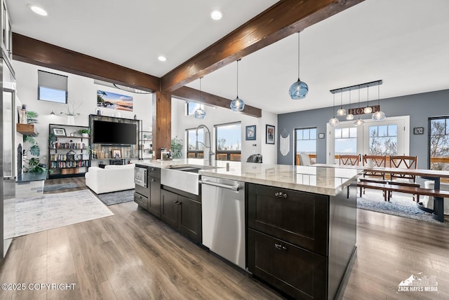 kitchen featuring a sink, beamed ceiling, stainless steel dishwasher, and dark wood finished floors