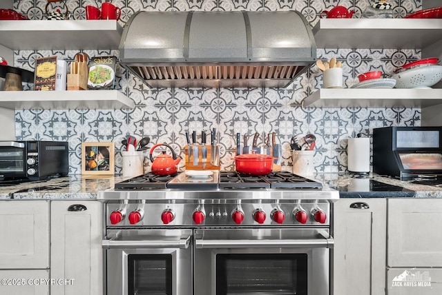 kitchen with open shelves, double oven range, extractor fan, and white cabinetry