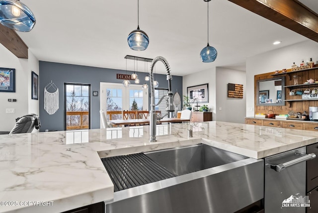 kitchen featuring a sink, light stone counters, and open floor plan