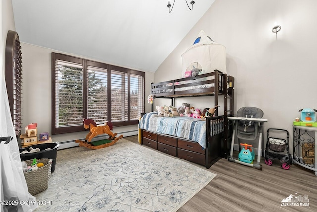 bedroom featuring baseboard heating, wood finished floors, and high vaulted ceiling