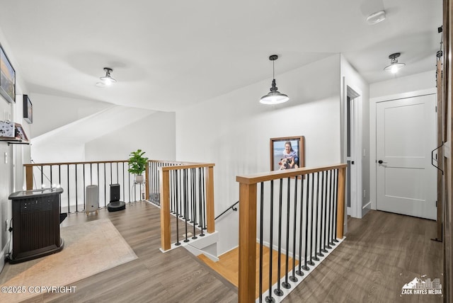 hall featuring wood finished floors, an upstairs landing, and baseboards