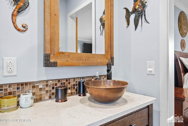 bathroom featuring backsplash, vanity, and a textured wall