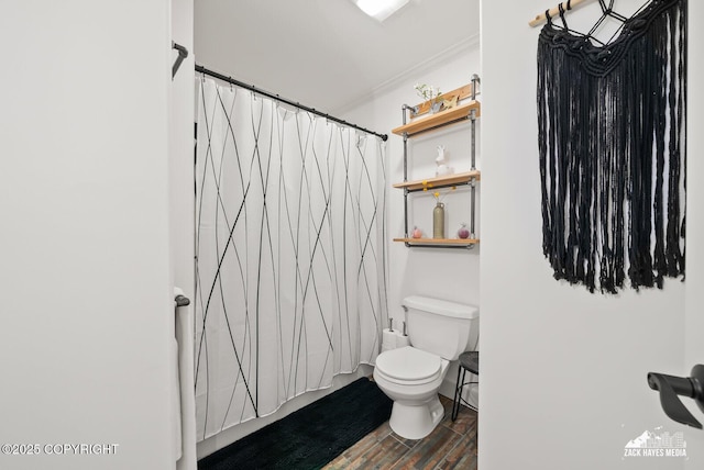 bathroom featuring a shower with shower curtain, wood finished floors, toilet, and ornamental molding