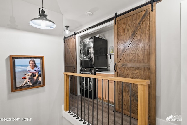 details featuring a barn door and stacked washer and clothes dryer