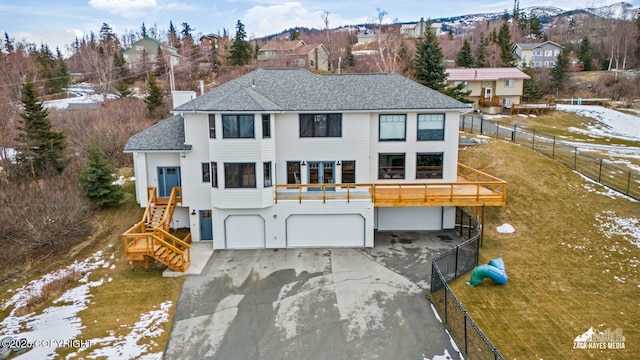 view of front of house featuring concrete driveway, an attached garage, fence, and roof with shingles