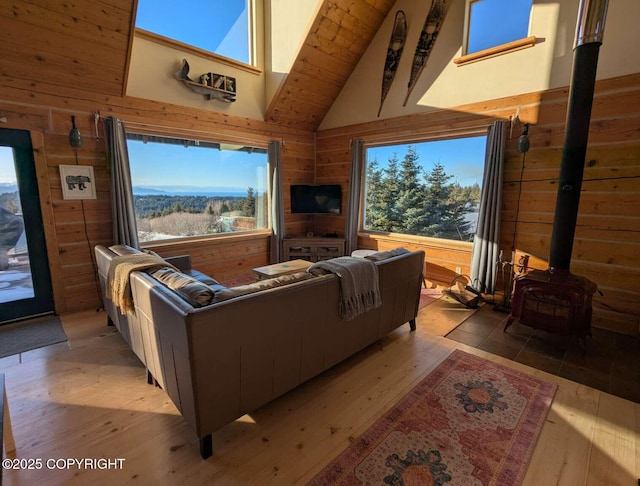 living room with a healthy amount of sunlight, wood walls, and light wood finished floors