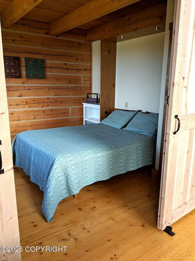 bedroom with wood walls, wood ceiling, wood finished floors, and beamed ceiling