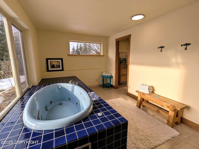 interior space with tile patterned flooring, a jacuzzi, and baseboards