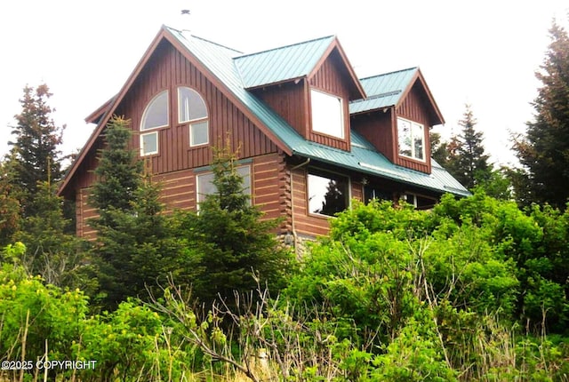 view of side of property featuring metal roof and log siding