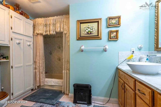 bathroom featuring tile patterned flooring, baseboards, shower / tub combo, and vanity