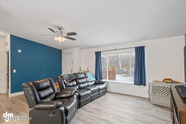 living room with light wood-type flooring, baseboards, and a ceiling fan