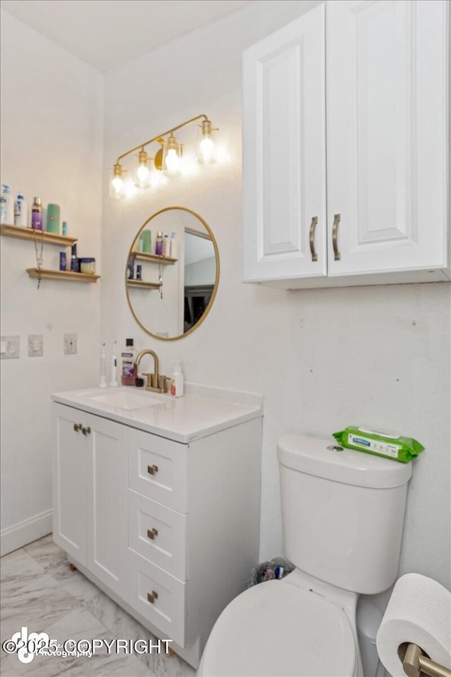 bathroom featuring marble finish floor, baseboards, vanity, and toilet