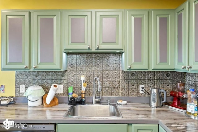 kitchen featuring tasteful backsplash, light countertops, a sink, and green cabinets